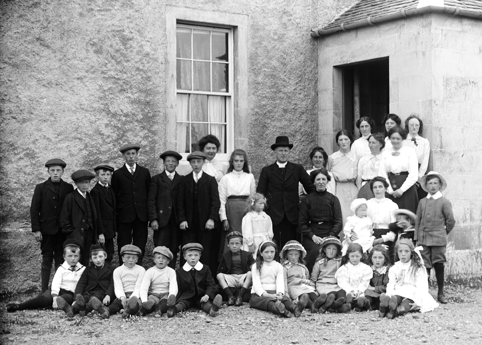 Sunday School Group at the Manse, c1914. The Rev. Logan in black hat, his wife Annie in front of him with hands clasped, son John furthest right in white cap and tweed suit.